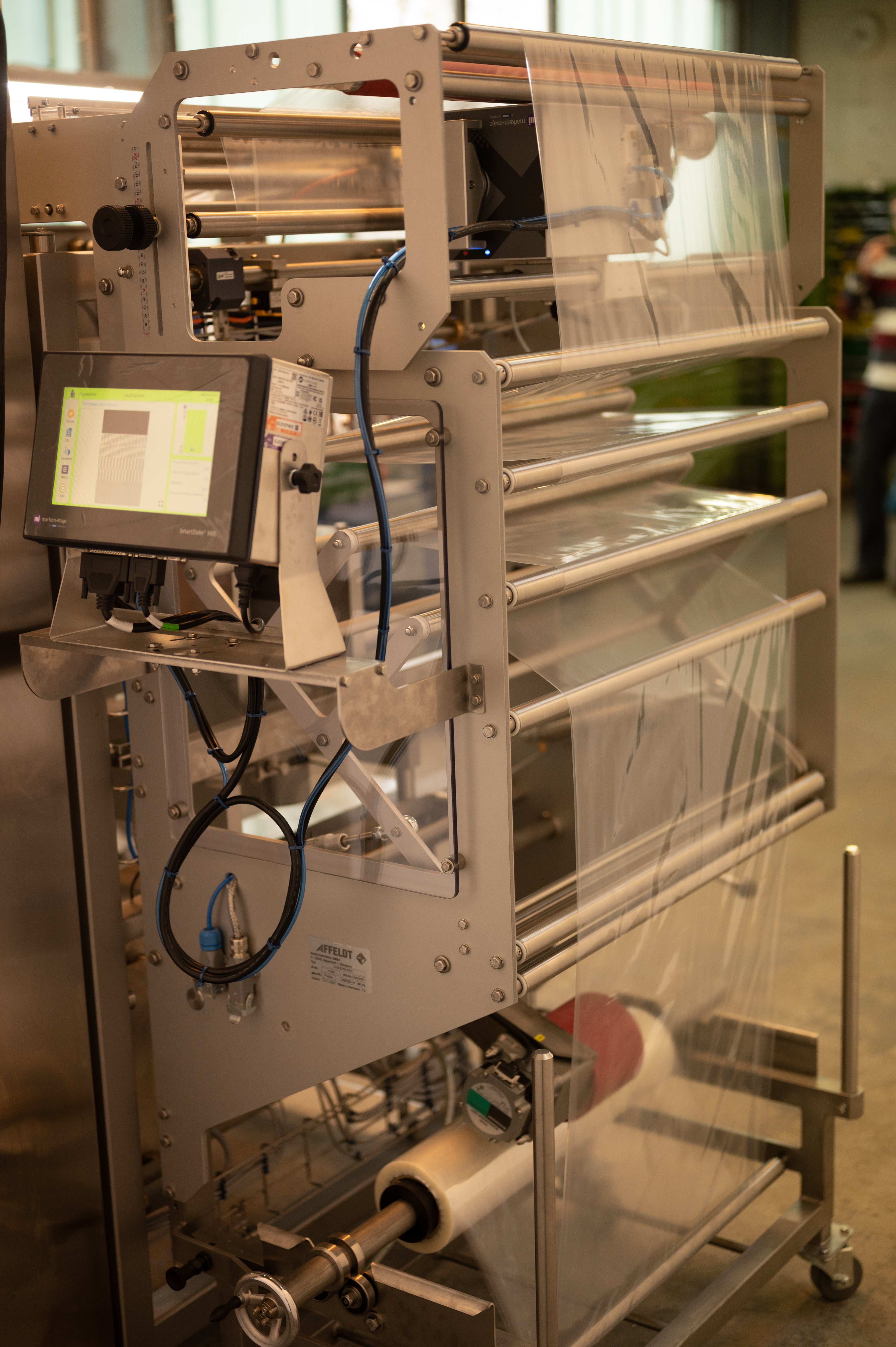 A long strip of transparent film runs on rollers on the AVN E350 SCD form fill and seal machine